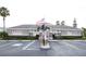 Community clubhouse with parking and American and military flags at 2749 Plantain Dr, Holiday, FL 34691