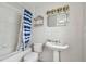 Small bathroom with pedestal sink and tub at 306 180Th E Ave, Redington Shores, FL 33708