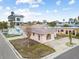 Pink single story home with gray roof, landscaping, and a small yard at 306 180Th E Ave, Redington Shores, FL 33708