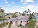 Pink single story home with gray roof, landscaping, and a small yard at 306 180Th E Ave, Redington Shores, FL 33708