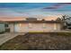 Pink single story home with gray roof, landscaping, and a small yard at 306 180Th E Ave, Redington Shores, FL 33708