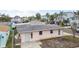 Pink single story home with gray roof, landscaping, and a small yard at 306 180Th E Ave, Redington Shores, FL 33708