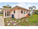 Side of a pink house with a blue recycling bin and some building materials at 306 180Th E Ave, Redington Shores, FL 33708