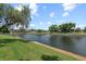 Scenic waterfront view with lush landscaping and a tranquil fountain at 4366 Summersun Dr, New Port Richey, FL 34652