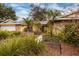 Front yard with palm trees and a wrought-iron bench at 531 Garrard Dr, Temple Terrace, FL 33617