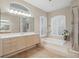 Bathroom with a soaking tub, shower, and double vanity at 6114 Kingbird Manor Dr, Lithia, FL 33547