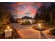 Well-lit home exterior at dusk with landscaping at 6114 Kingbird Manor Dr, Lithia, FL 33547