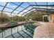 Serene screened pool and spa with brick patio and natural rock features at 6114 Kingbird Manor Dr, Lithia, FL 33547