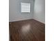 Spacious bedroom with laminate wood floors and window at 7638 Woodbridge Blvd, Tampa, FL 33615