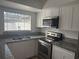 Modern kitchen featuring stainless steel appliances and granite countertops at 7638 Woodbridge Blvd, Tampa, FL 33615