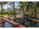 Serene backyard with gazebo, pond, waterfall, and lush landscaping at 8755 Commodore Dr, Seminole, FL 33776