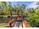 Wooden footbridge over a calm pond in a tropical setting at 8755 Commodore Dr, Seminole, FL 33776