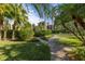 Brick pathway meanders through lush landscaping toward a home at 8755 Commodore Dr, Seminole, FL 33776