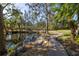 Curving brick pathway alongside a pond with lush landscaping at 8755 Commodore Dr, Seminole, FL 33776