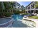 Inviting freeform pool with spa and lounge chairs, surrounded by tropical landscaping at 8755 Commodore Dr, Seminole, FL 33776