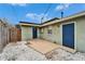 Small backyard patio with access to a blue door and gravel ground at 1022 Canal St, Ruskin, FL 33570