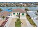 Aerial view of waterfront home with two-car garage and landscaped yard at 11325 5Th E St, Treasure Island, FL 33706