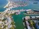 Aerial view of waterfront community with lush landscaping, boat docks, and nearby beach at 12482 Capri N Cir # 4, Treasure Island, FL 33706
