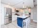 Modern kitchen with stainless steel appliances, white cabinets, and a blue island at 12482 Capri N Cir # 4, Treasure Island, FL 33706