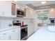 Updated kitchen featuring stainless steel appliances and white cabinetry at 12482 Capri N Cir # 4, Treasure Island, FL 33706