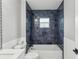 Bathroom with dark blue tile shower and white vanity at 126 90Th Ave, Treasure Island, FL 33706