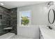 Modern bathroom with walk-in shower, window, and vanity with a large mirror at 126 90Th Ave, Treasure Island, FL 33706