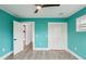 Bedroom with teal walls, wood-look floors, and white doors at 126 90Th Ave, Treasure Island, FL 33706