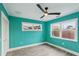 Light teal bedroom with wood-look flooring, ceiling fan, and two windows at 126 90Th Ave, Treasure Island, FL 33706