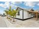 Charming white cottage with gray accents, a covered carport, and lush landscaping at 126 90Th Ave, Treasure Island, FL 33706