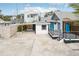 Front view of a renovated beach cottage, showcasing a deck and carport at 126 90Th Ave, Treasure Island, FL 33706