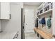 Well-designed laundry room with storage, a bench, and built-in shelving at 13038 Paddock Woods Pl, Riverview, FL 33579