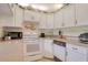 Well-equipped kitchen with white cabinets, granite counters, and modern appliances at 1488 Pine Glen Ln # B2, Tarpon Springs, FL 34688