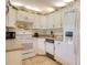 White kitchen features granite countertops and stainless steel appliances at 1488 Pine Glen Ln # B2, Tarpon Springs, FL 34688