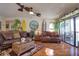 Bright living room with hardwood floors, leather couches and a ceiling fan at 1488 Pine Glen Ln # B2, Tarpon Springs, FL 34688