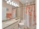 Bathroom with shower/tub combo, granite countertop, and peach accents at 15618 Aurora Lake Cir, Wimauma, FL 33598