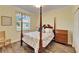 Bedroom with a four-poster bed, wooden dresser, and window at 15618 Aurora Lake Cir, Wimauma, FL 33598