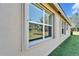 Window with hurricane shutters, showcasing the backyard view at 15618 Aurora Lake Cir, Wimauma, FL 33598