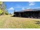Side view of the house showing a large backyard and screened patio at 15618 Aurora Lake Cir, Wimauma, FL 33598