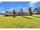 Rear view of house showcasing the landscaping and lawn at 15618 Aurora Lake Cir, Wimauma, FL 33598