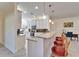 Kitchen features granite countertops, white cabinets, and island with seating at 15618 Aurora Lake Cir, Wimauma, FL 33598
