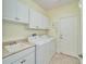 Laundry room with washer, dryer, cabinets, and utility sink at 15618 Aurora Lake Cir, Wimauma, FL 33598