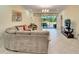 Spacious living area with a large sectional sofa and access to a patio at 15618 Aurora Lake Cir, Wimauma, FL 33598