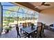 Screened patio with table and chairs, overlooking the backyard at 15618 Aurora Lake Cir, Wimauma, FL 33598