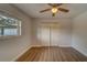 Bedroom with wood-look floors, ceiling fan and double doors at 1566 Long St, Clearwater, FL 33755