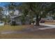 Exterior view of a gray house with a large tree and yard at 1566 Long St, Clearwater, FL 33755
