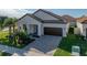 Single-story home with a brown door and brick driveway, featuring landscaping and a two-car garage at 16931 Scuba Crest St, Wimauma, FL 33598
