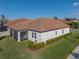 Rear view of house showcasing screened porch and landscaping at 16931 Scuba Crest St, Wimauma, FL 33598