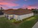 Evening view of house with screened porch and landscaping at 16931 Scuba Crest St, Wimauma, FL 33598