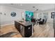 Open floor plan with kitchen island and living room with leather furniture at 16931 Scuba Crest St, Wimauma, FL 33598