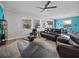 Spacious living area with leather furniture, ceiling fan, and large windows at 16931 Scuba Crest St, Wimauma, FL 33598